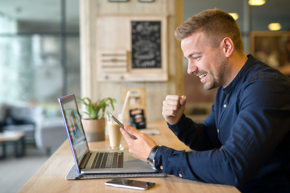 Homem Sorrindo Enquanto Realiza Uma Venda Online, Após Começar Um Negócio Do Zero.